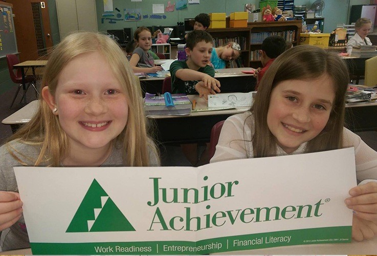 Kids holding up Junior Achievment sign