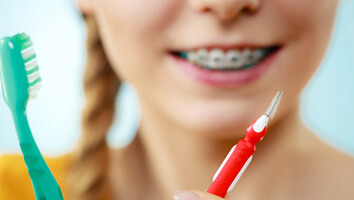 patient with braces cleaning teeth