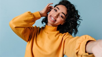 A pleased girl with braces taking a selfie