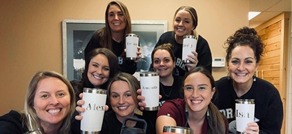 Smiling Webster orthodontic team members holding waterbottles