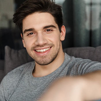 man smiling while sitting on couch 