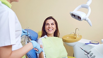 Woman shaking hands while sitting in dental chair