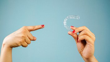 Someone pointing at an Invisalign tray