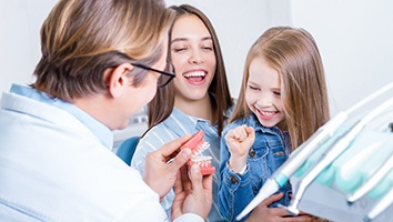 Orthodontist explaining orthodontic treatment to child and parent