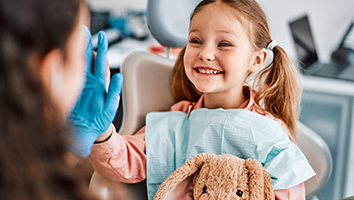 Child giving high-five to dental team member