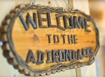 Wooden sign saying welcome to the Adirondacks