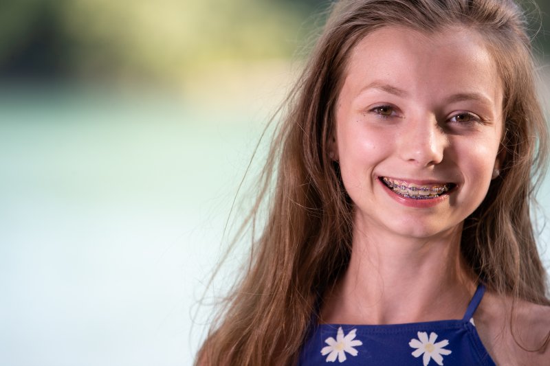 Teenage girl in blue dress smiling with braces
