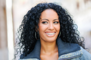 Woman smiling with orthodontics looking away from camera