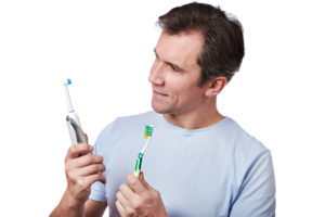 Orthodontist in Rochester comparing electric and manual toothbrushes