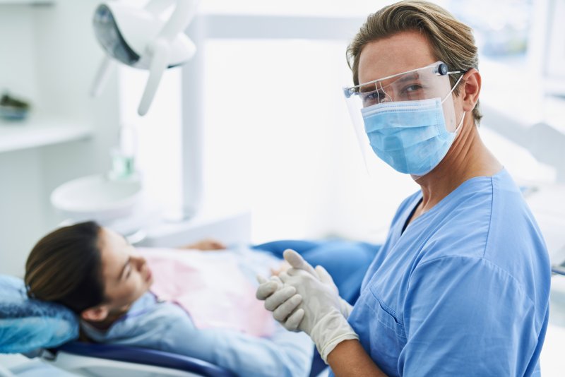 Orthodontist wearing PPE with patient