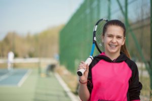 Girl playing tennis with braces  