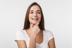 Young woman smiling after seeing orthodontist in Rochester