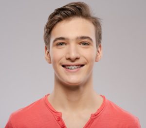 Young man smiling after visiting an orthodontist in Rochester