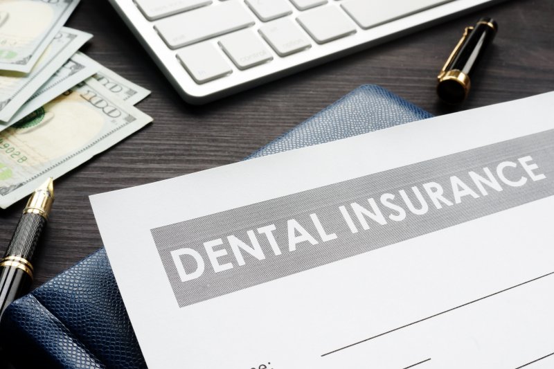 Dental insurance form on desktop with money