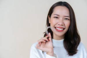 Woman smiling with Invisalign while looking at the camera