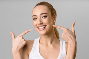 Woman pointing to her white teeth