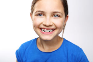 Young girl with braces smiling on white background