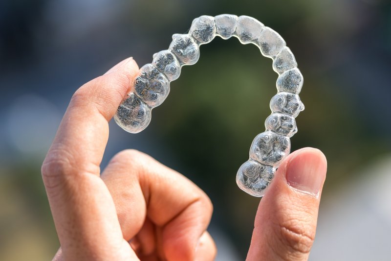 Close-up of hand holding an Invisalign aligner