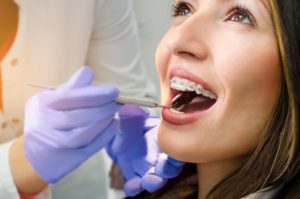 a woman getting her braces examined by a dentist